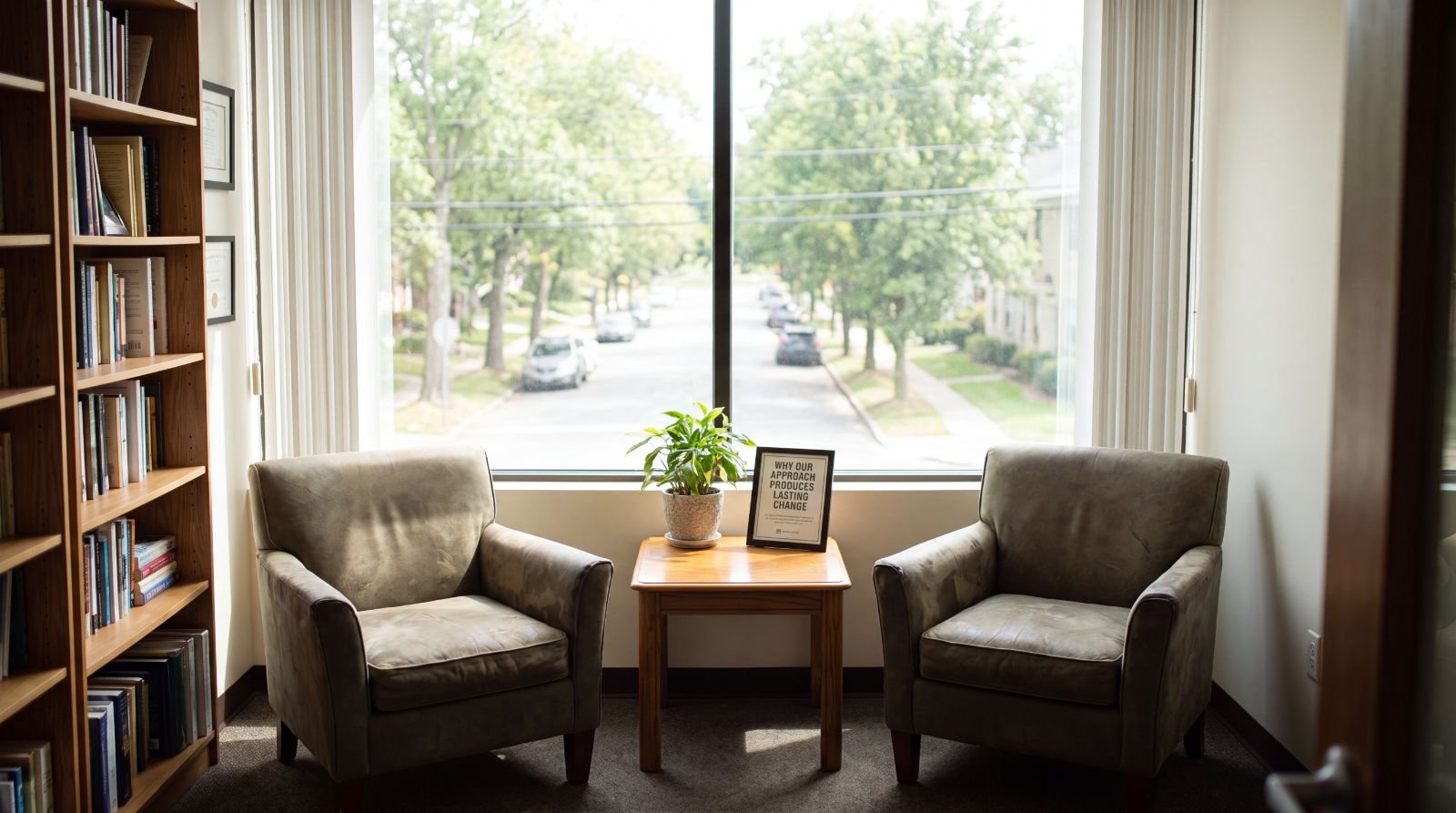 Two armchairs angled toward each other beside a sunlit window in the Old City office